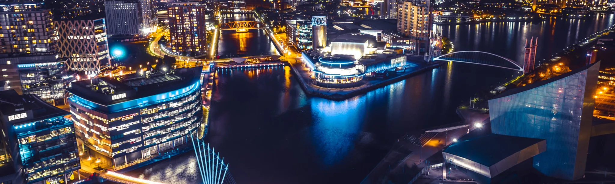 A breathtaking aerial view of Manchester at night, showcasing the mesmerizing lights and vibrant energy below.