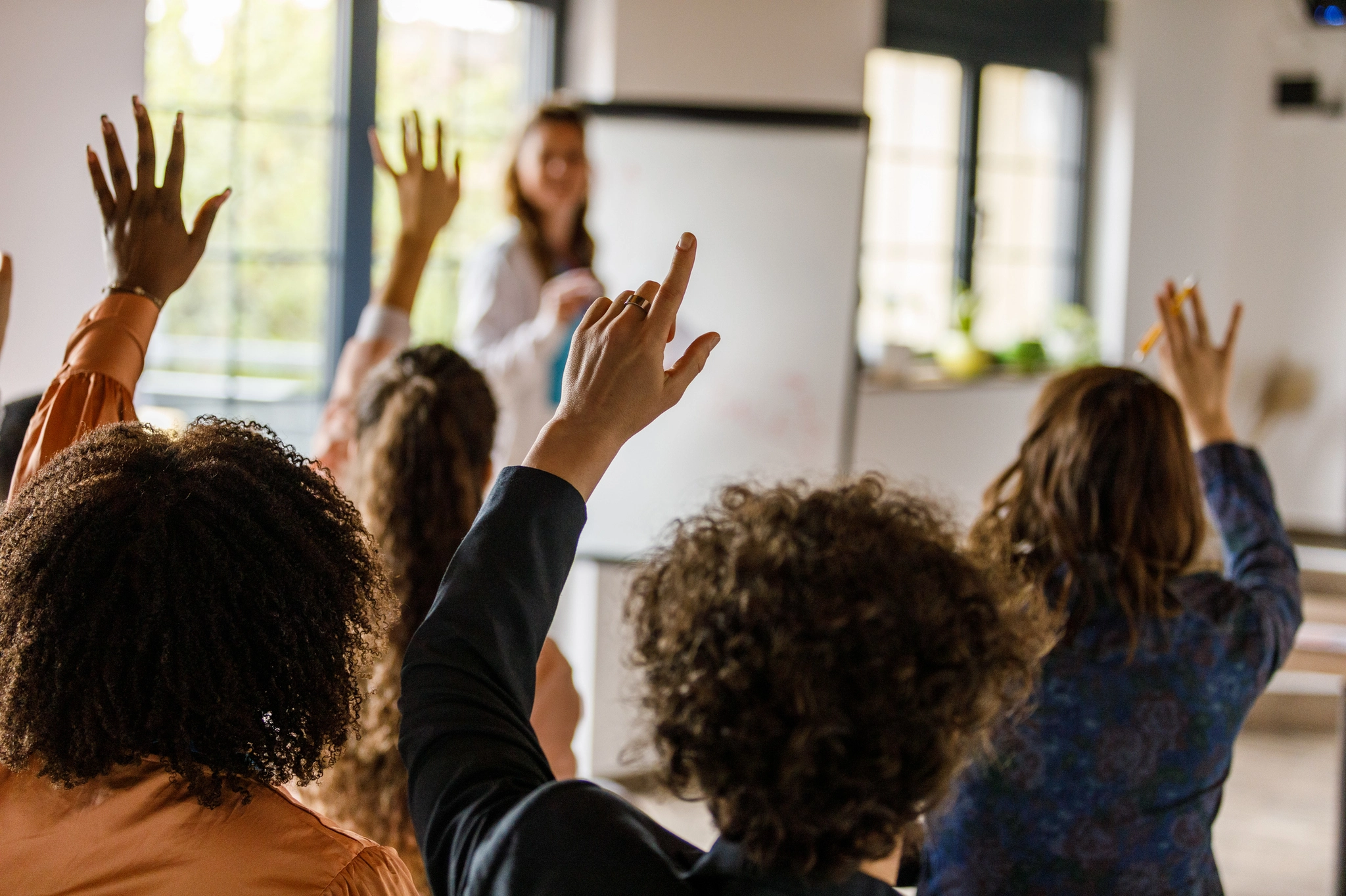 Students in a classroom asking questions