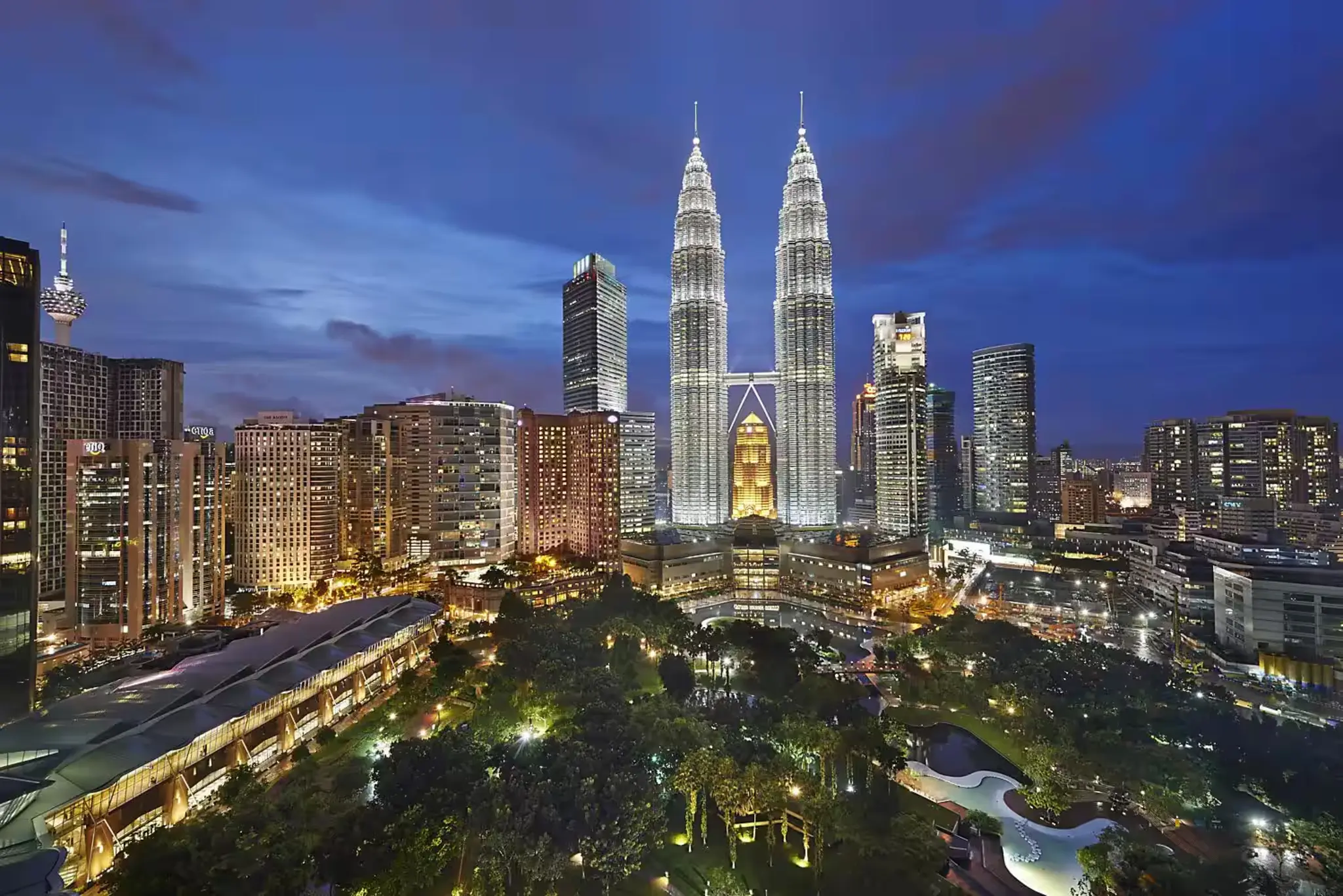 The Petronas Towers illuminated at night, showcasing their stunning architecture against the Kuala Lumpur skyline.