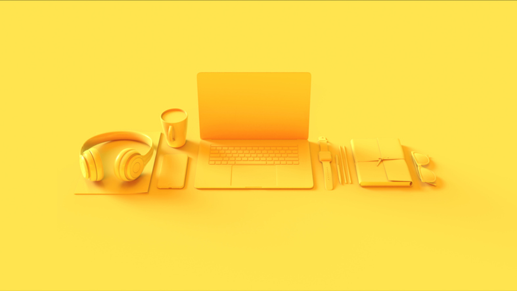 Yellow laptop, notebook, pen, and coffee cup on a matching yellow background