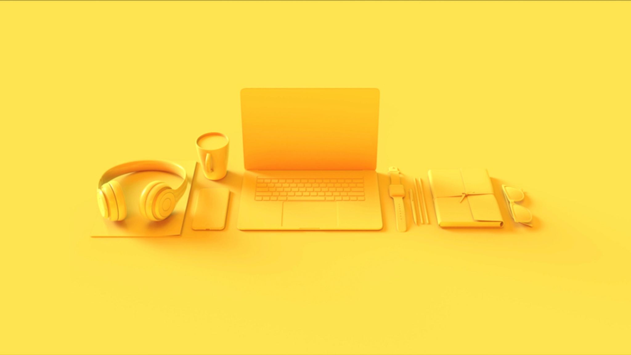 Yellow laptop, notebook, pen, and coffee cup on a matching yellow background