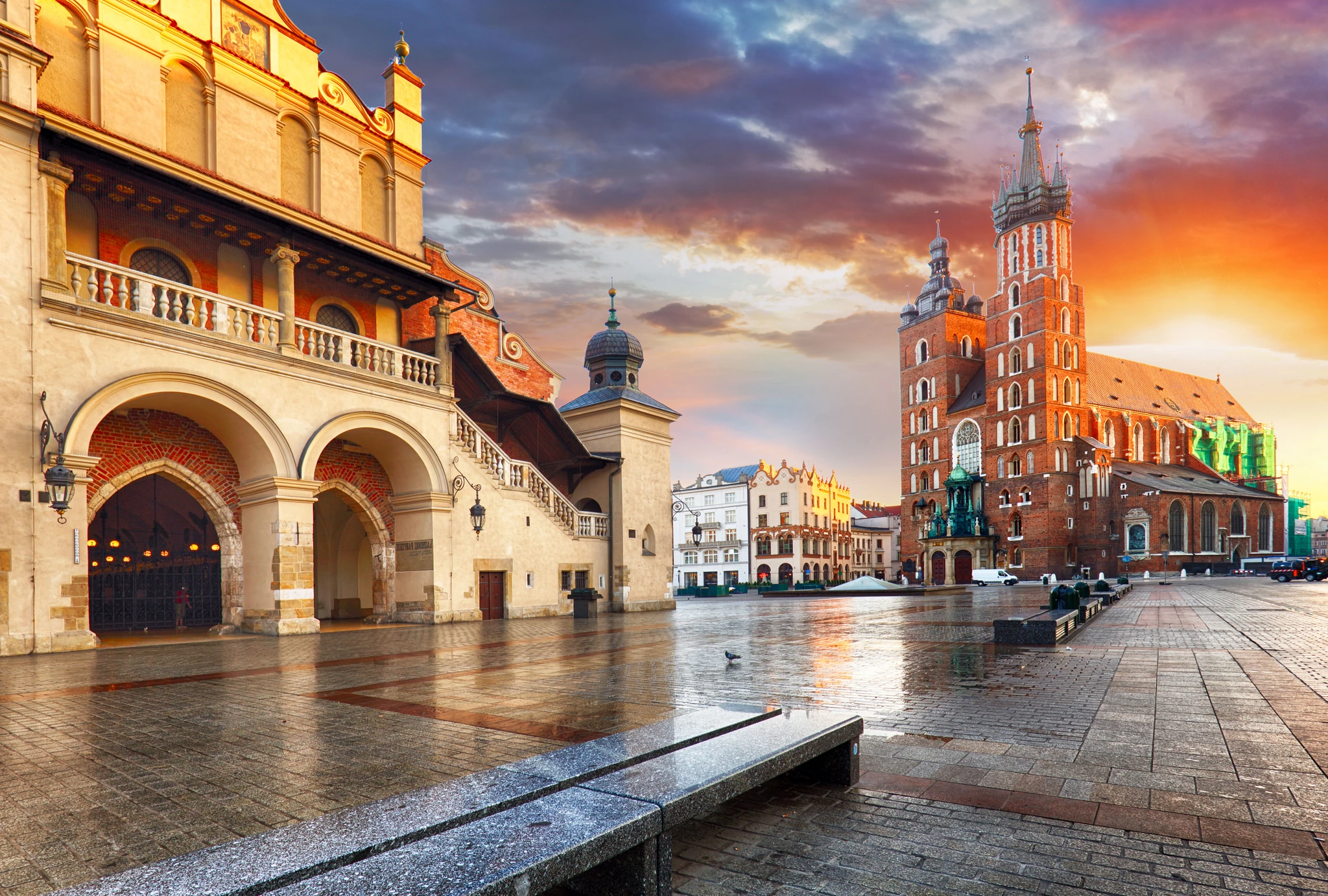 Sunset over Krakow's city square, casting warm hues on historic buildings and creating a serene evening atmosphere.
