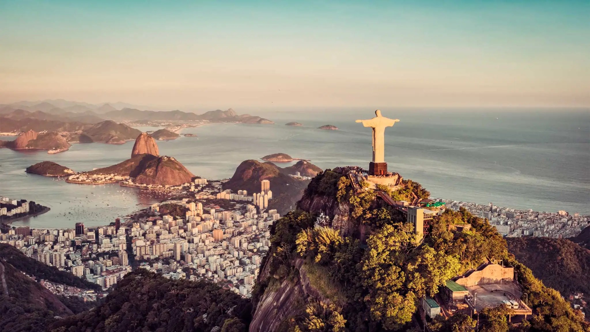A panoramic view of Rio de Janeiro, Brazil, showcasing its iconic mountains, beaches, and vibrant cityscape.